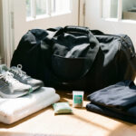 Sac de sport ouvert et aéré avec une serviette propre, des chaussures de course, un sachet désodorisant naturel et des vêtements pliés.